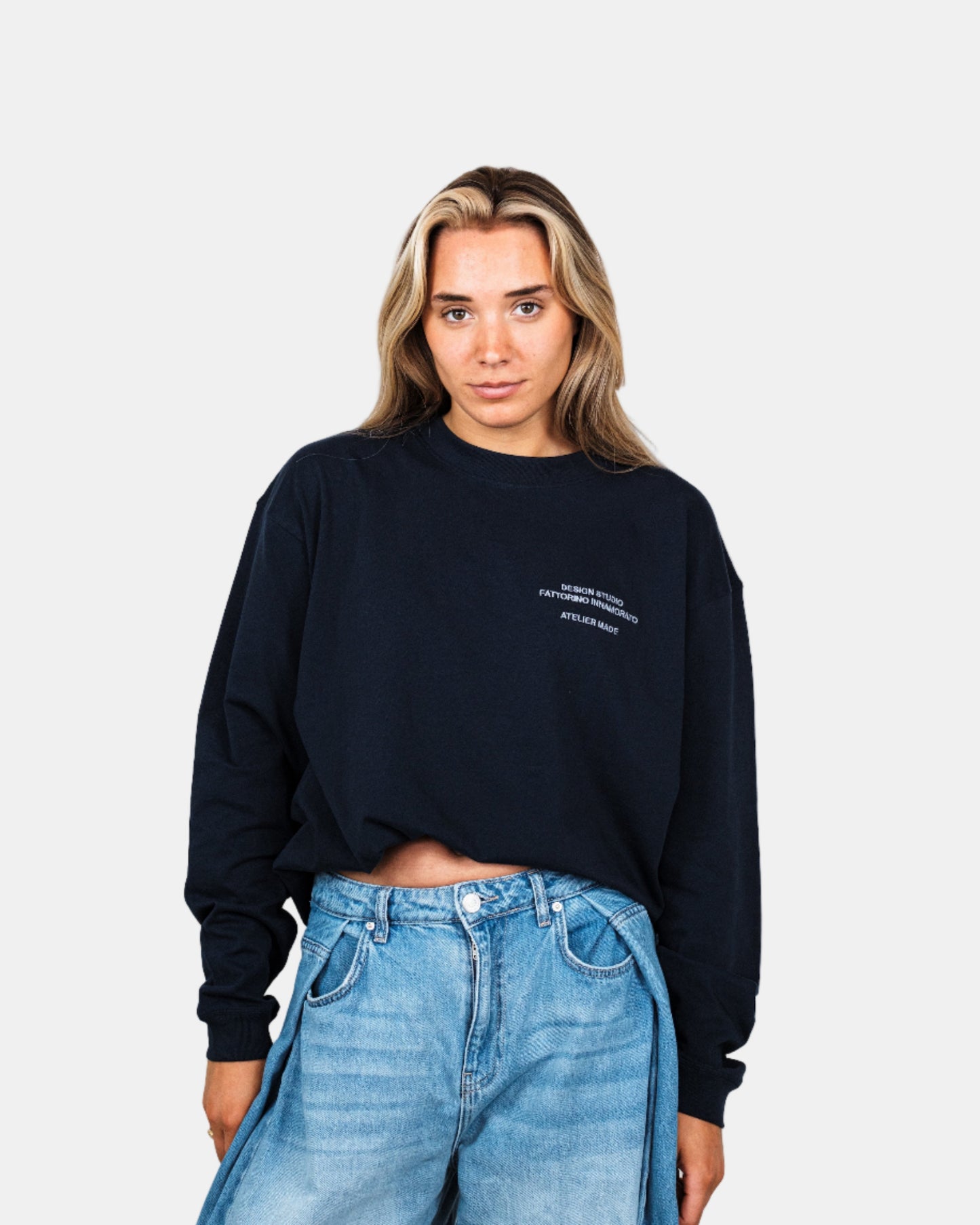 Woman wearing a navy long-sleeve shirt with a logo on a white background. Fattorino Innamorato City Longsleeve