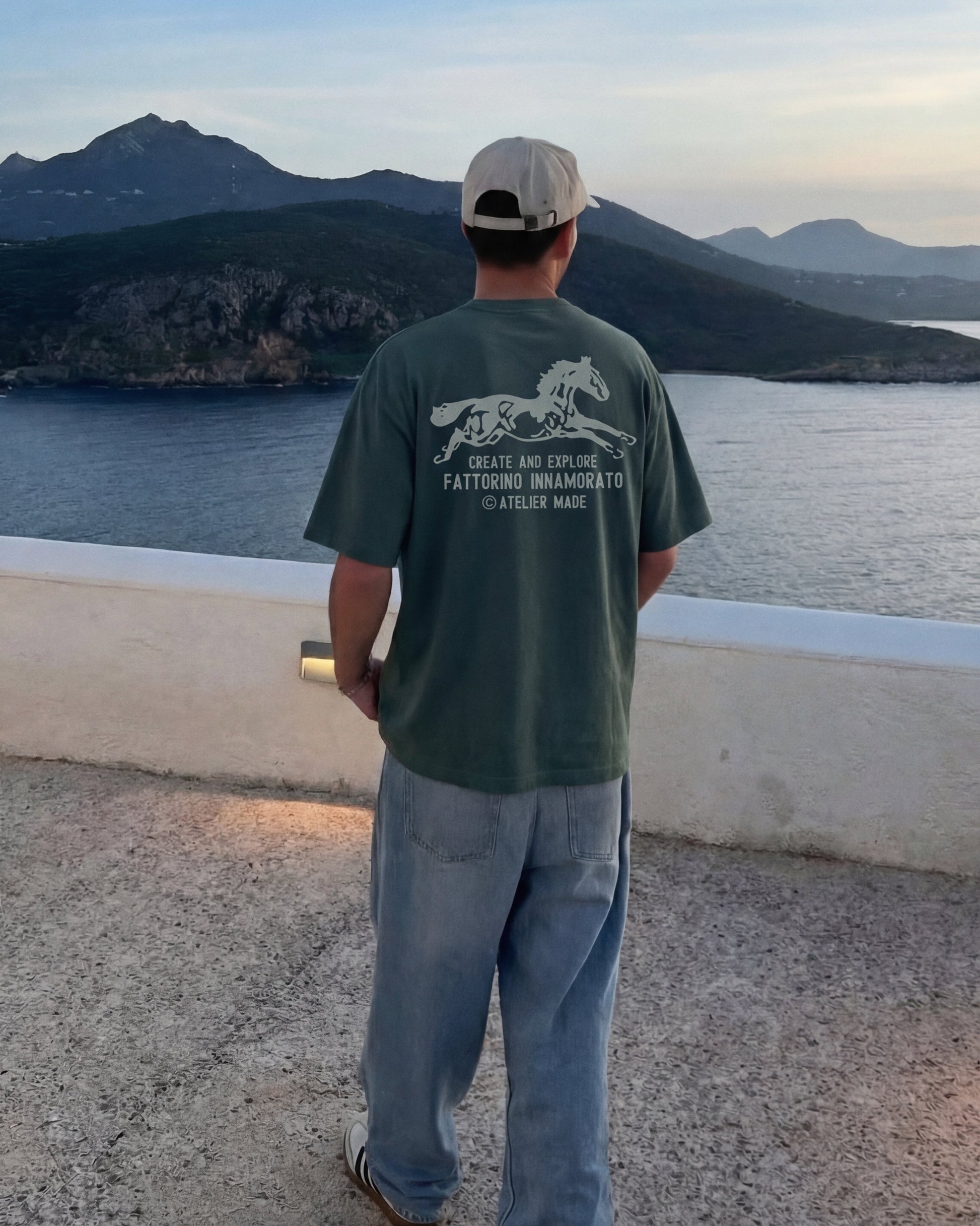 Green t-shirt with a horse graphic and text on the back against a white background. Fattorino Innamorato cavallo green
