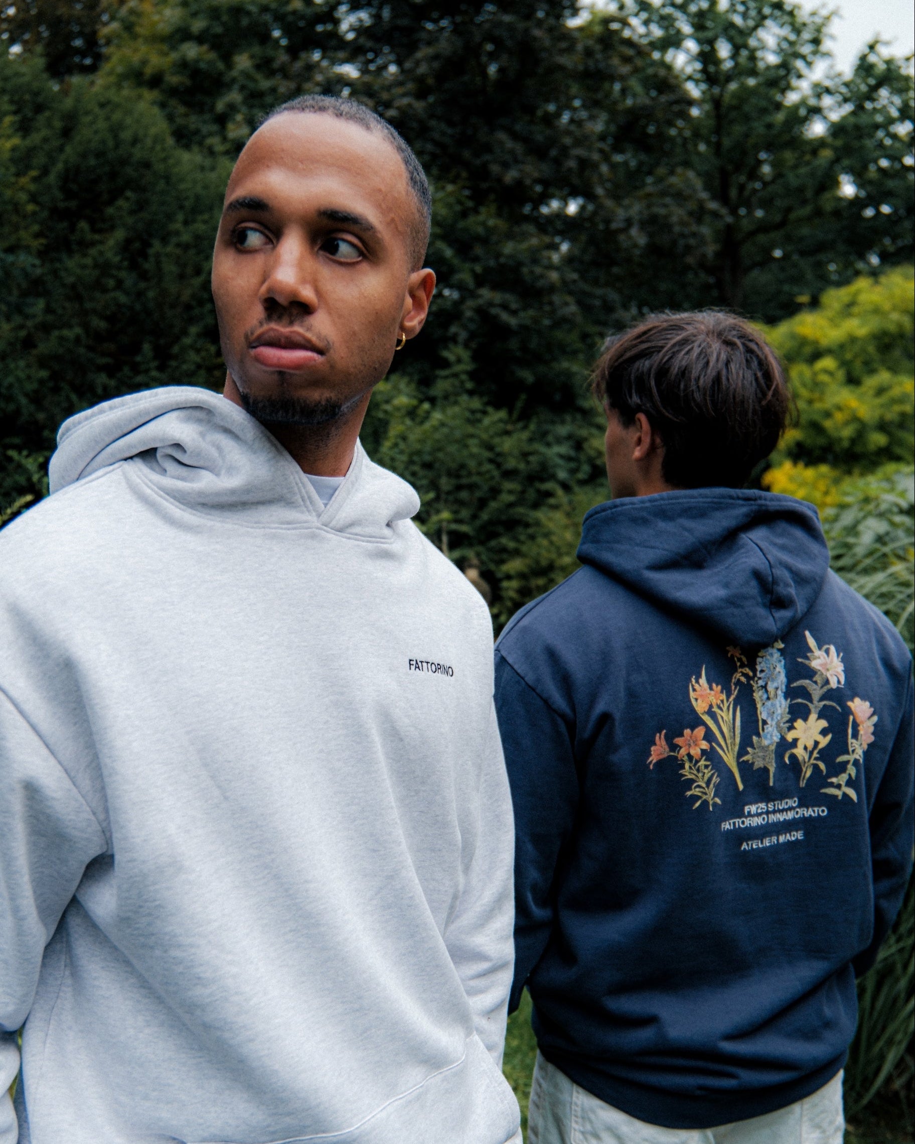 Fattorino Innamorato navy acid washed hoodie with flowers print. Two models with hoodies. Grey Fattorino melange hoodie
