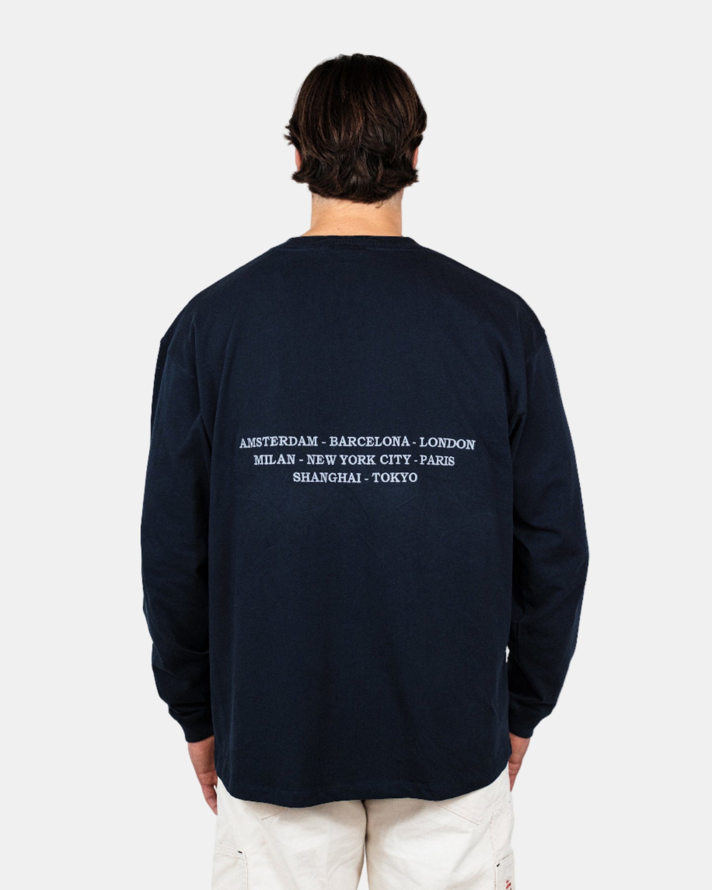 Man wearing a navy long-sleeve shirt with a logo on a white background. Fattorino Innamorato City Longsleeve