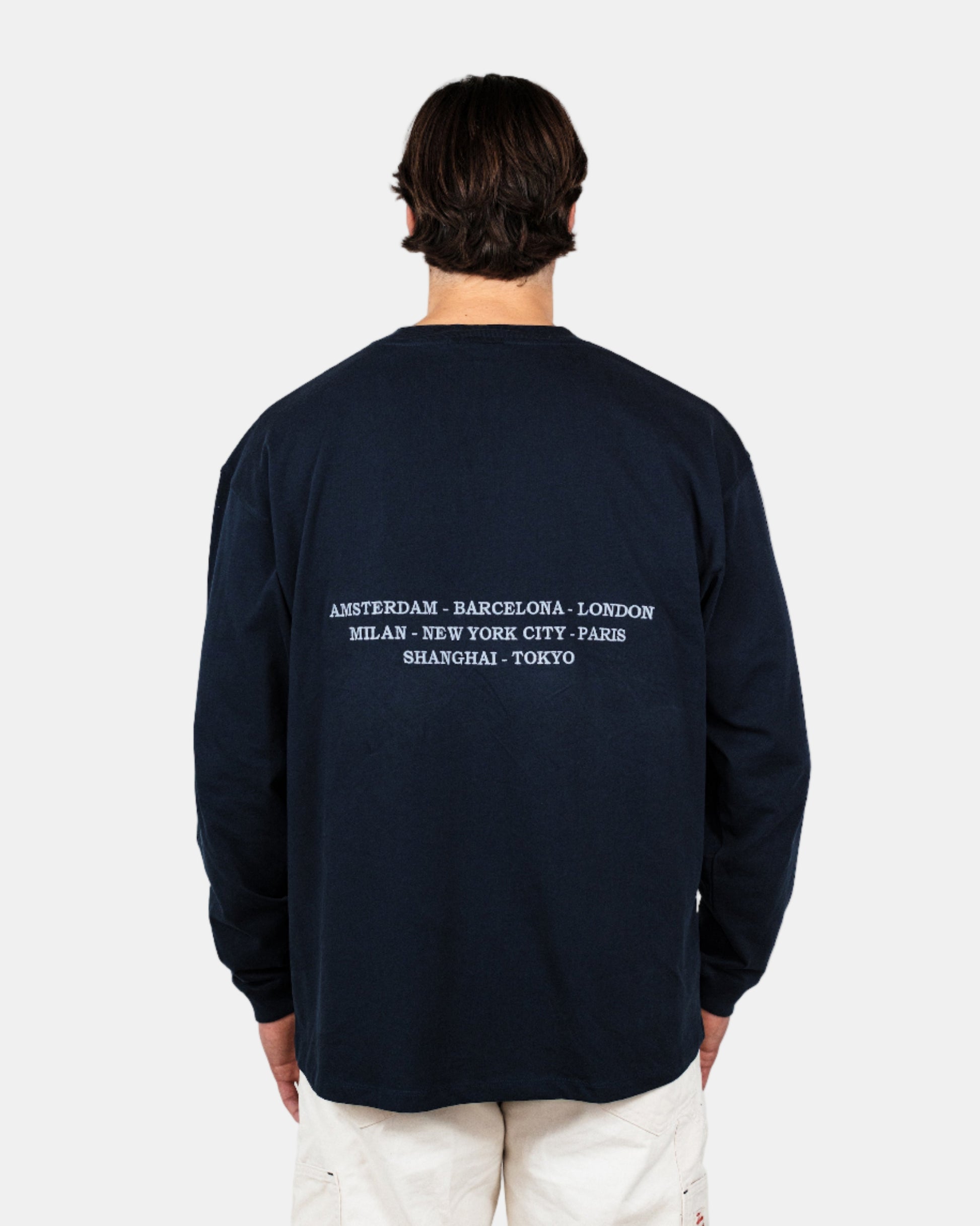 Man wearing a navy long-sleeve shirt with a logo on a white background. Fattorino Innamorato City Longsleeve