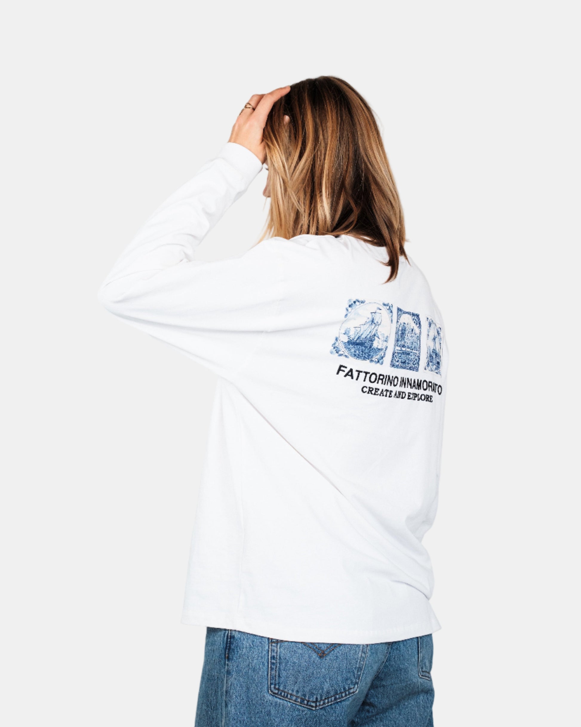 Person wearing a white longsleeve tshirt with a graphic design on the back against a plain background. Fattorino Innamorato Dutch 