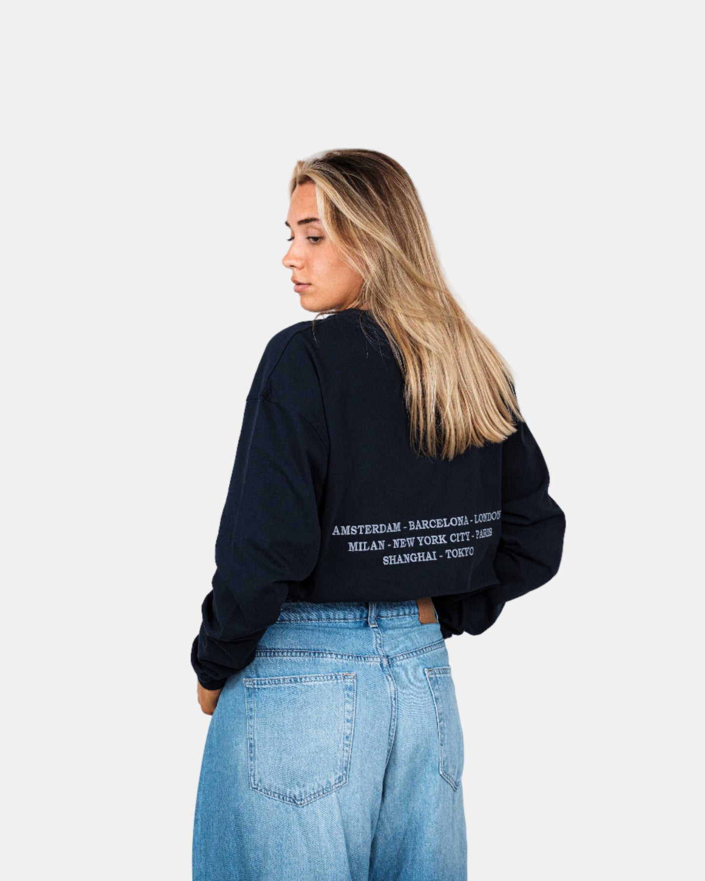 Woman wearing a navy long-sleeve shirt with a logo on a white background. Fattorino Innamorato City Longsleeve

