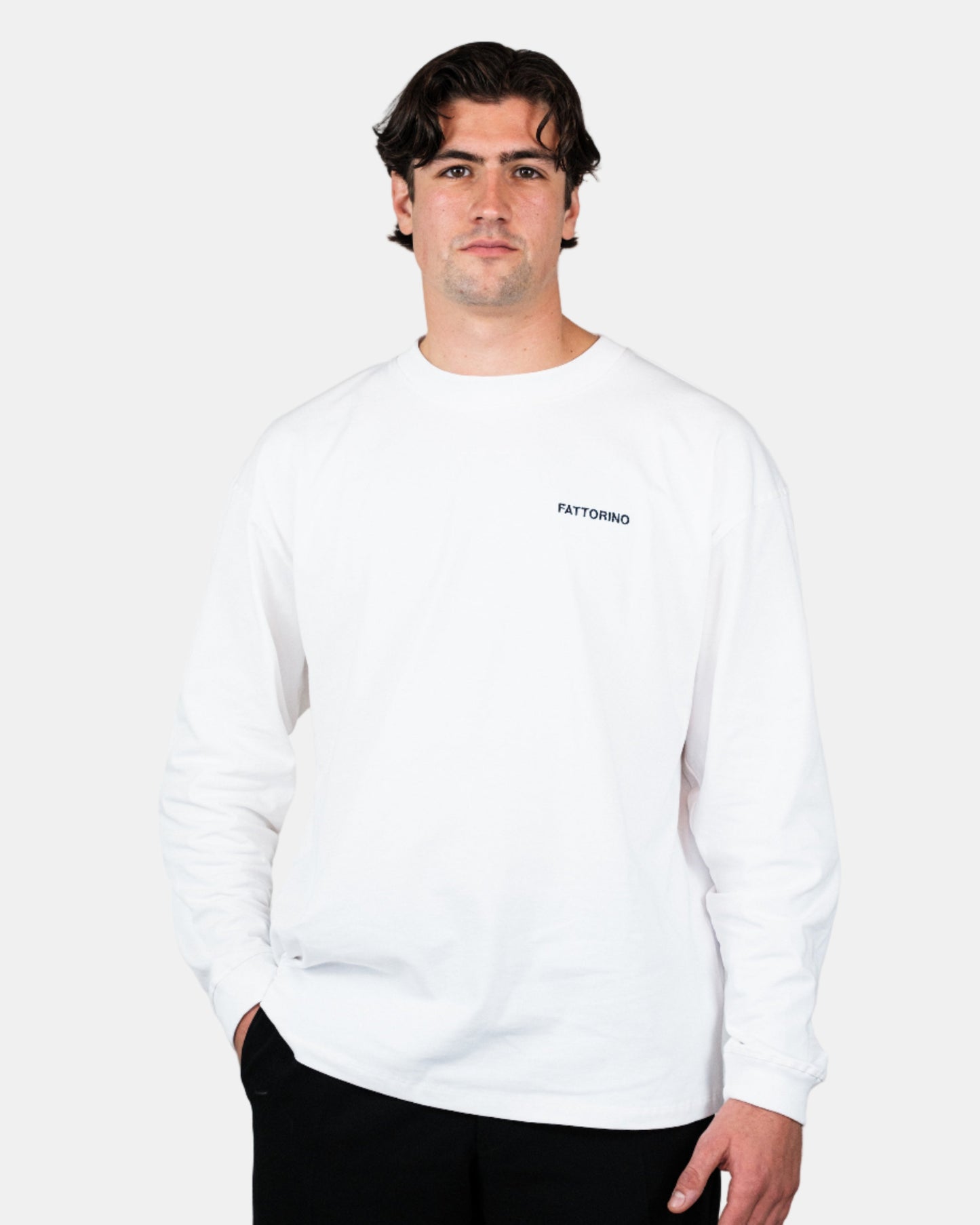 Person wearing a white longsleeve tshirt with text on a plain background. Fattorino Innamorato play cards 