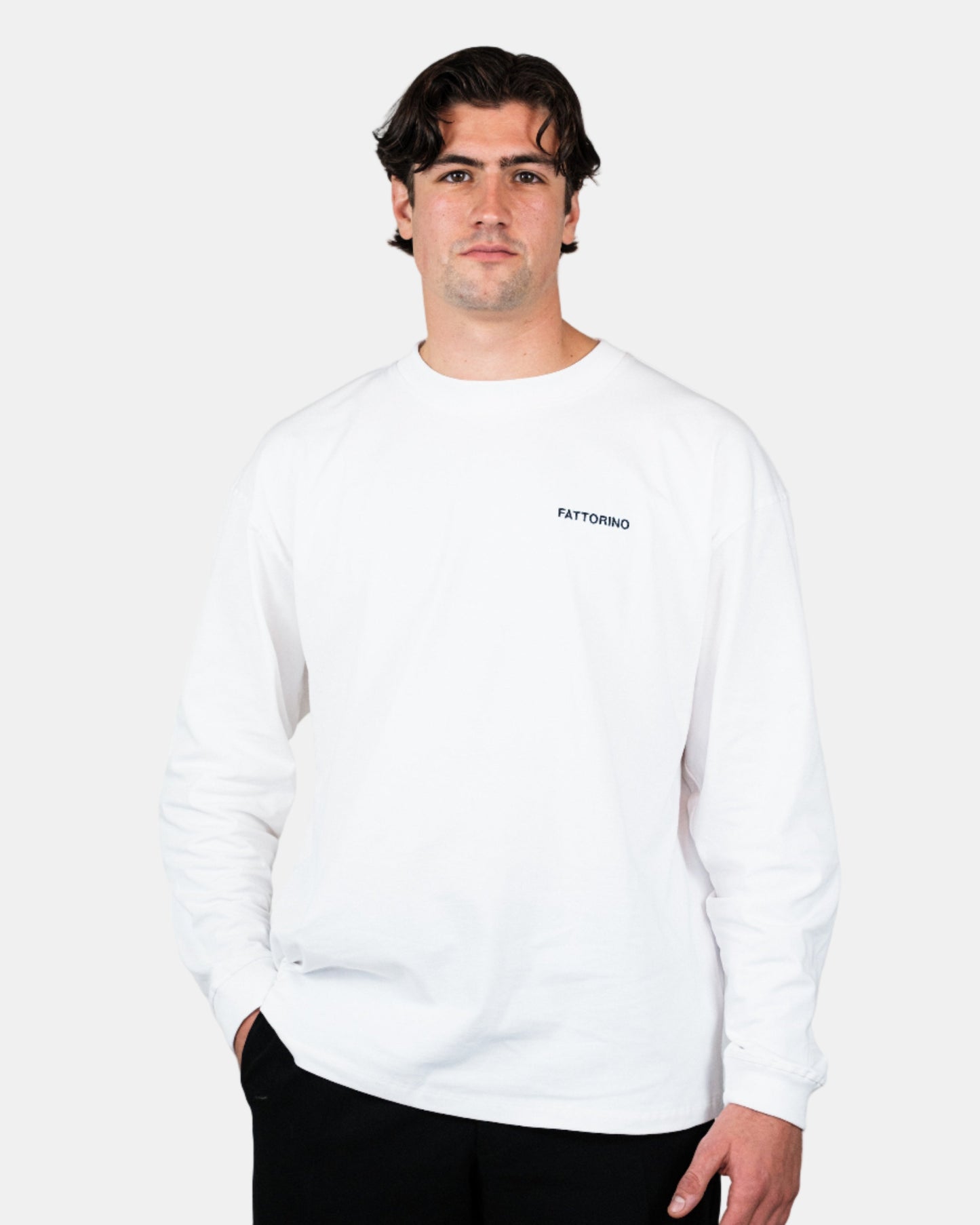 Person wearing a white longsleeve with text on a plain background. Fattorino Innamorato Dutch