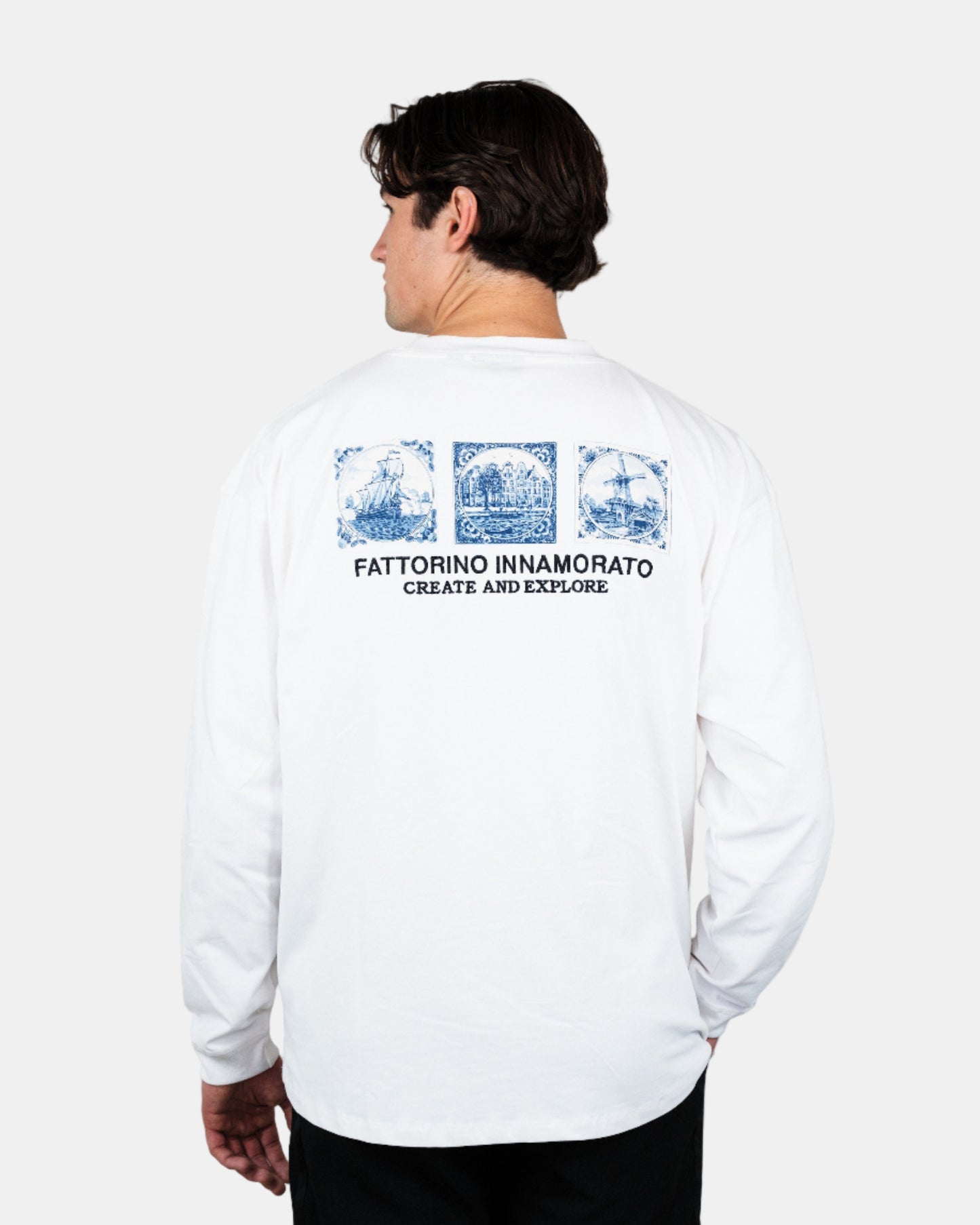 Person wearing a white long-sleeve shirt with graphics and text on the back, standing against a plain background. Fattorino Innamorato Dutch longsleeve