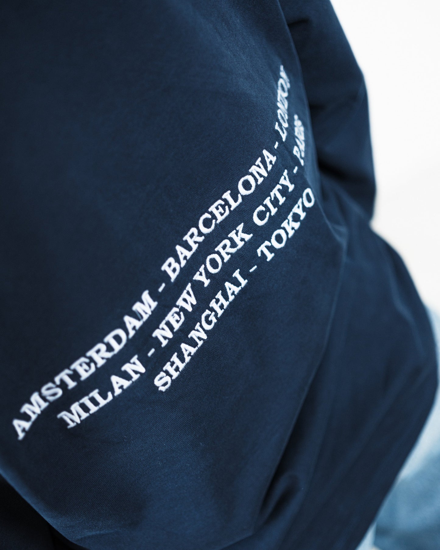 Woman wearing a navy long-sleeve shirt with a logo on a white background. Fattorino Innamorato City Longsleeve

