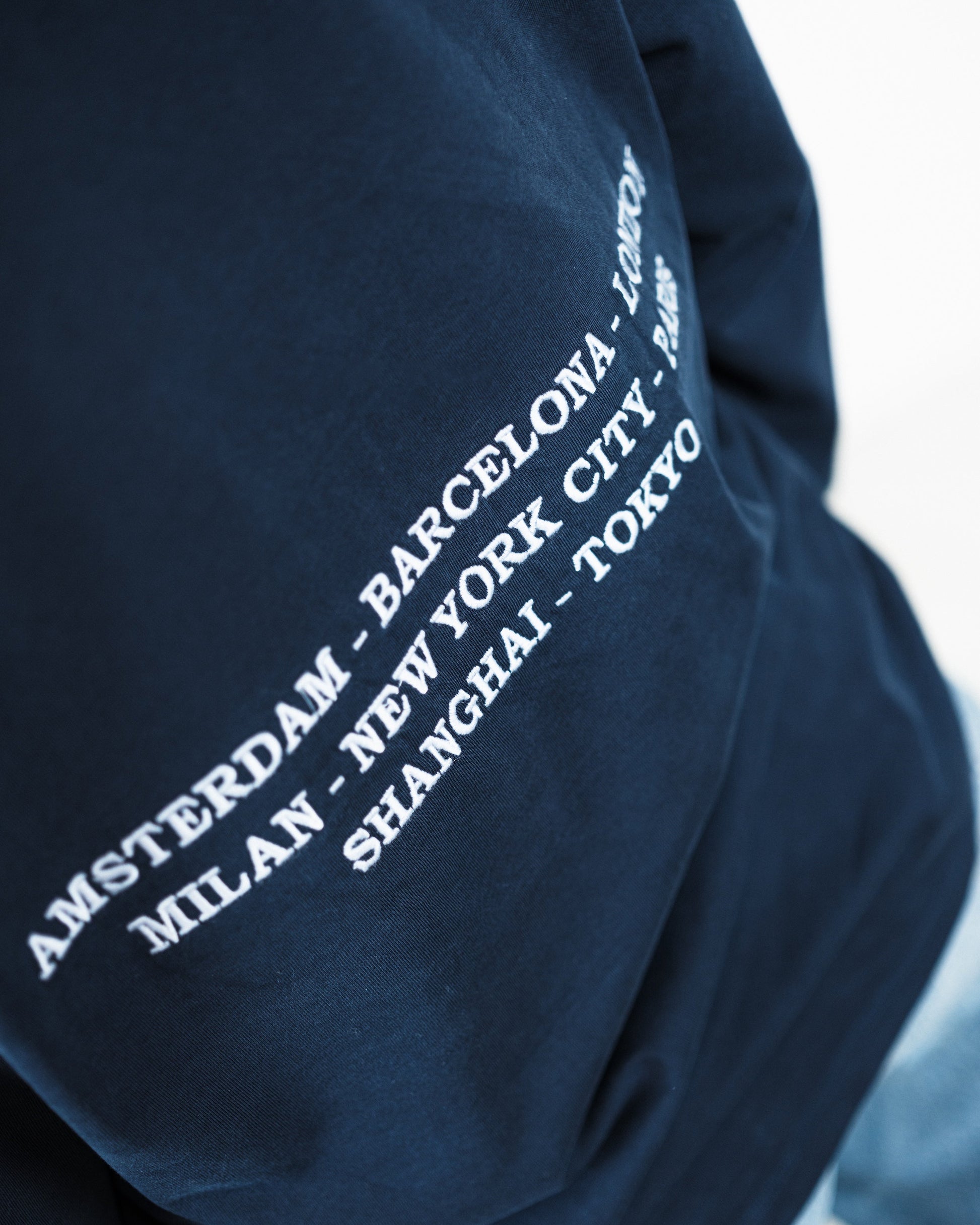 Woman wearing a navy long-sleeve shirt with a logo on a white background. Fattorino Innamorato City Longsleeve

