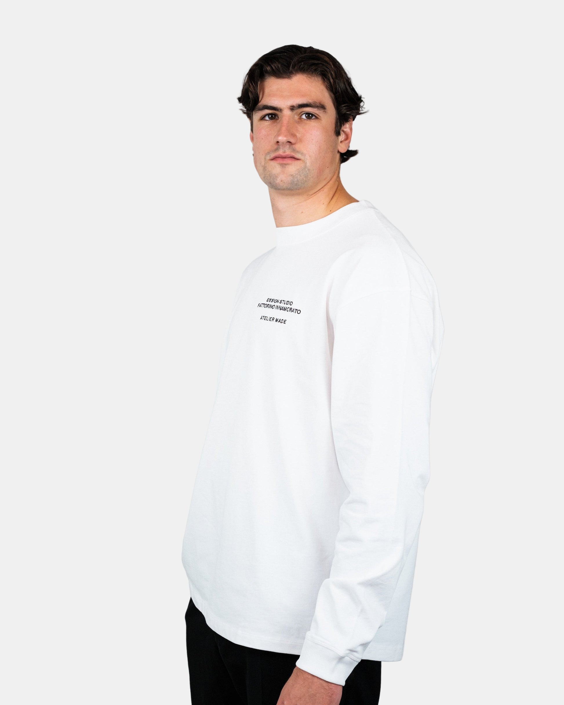 Man wearing a white long-sleeve shirt with text on a plain background. Fattorino Innamorato pool longsleeve
