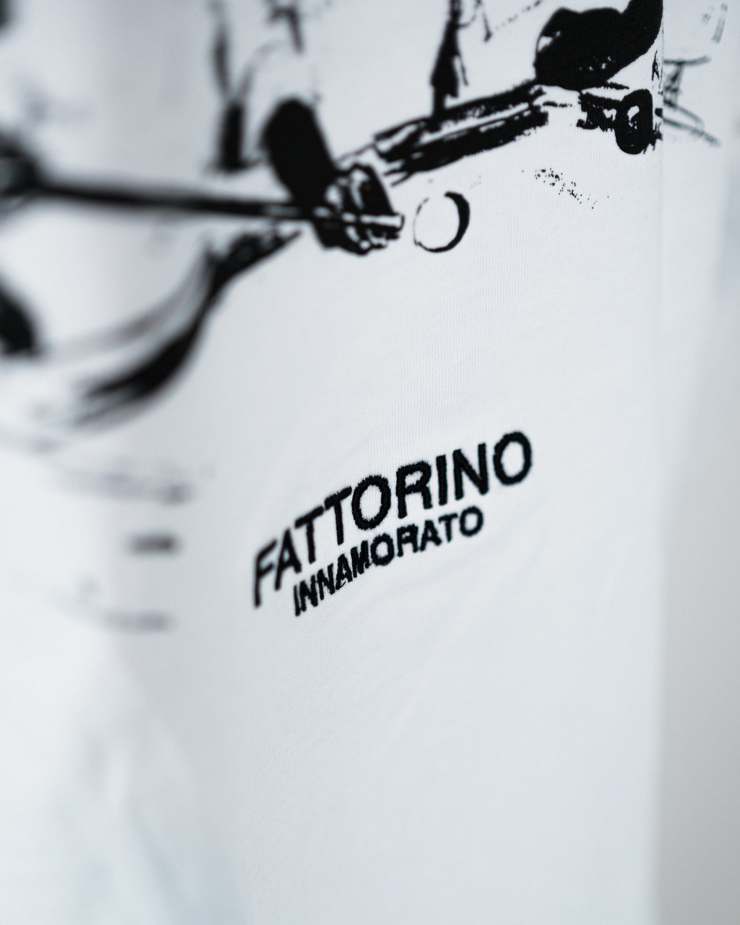 White shirt with 'Fattorino Innamorato' logo on a blurred background