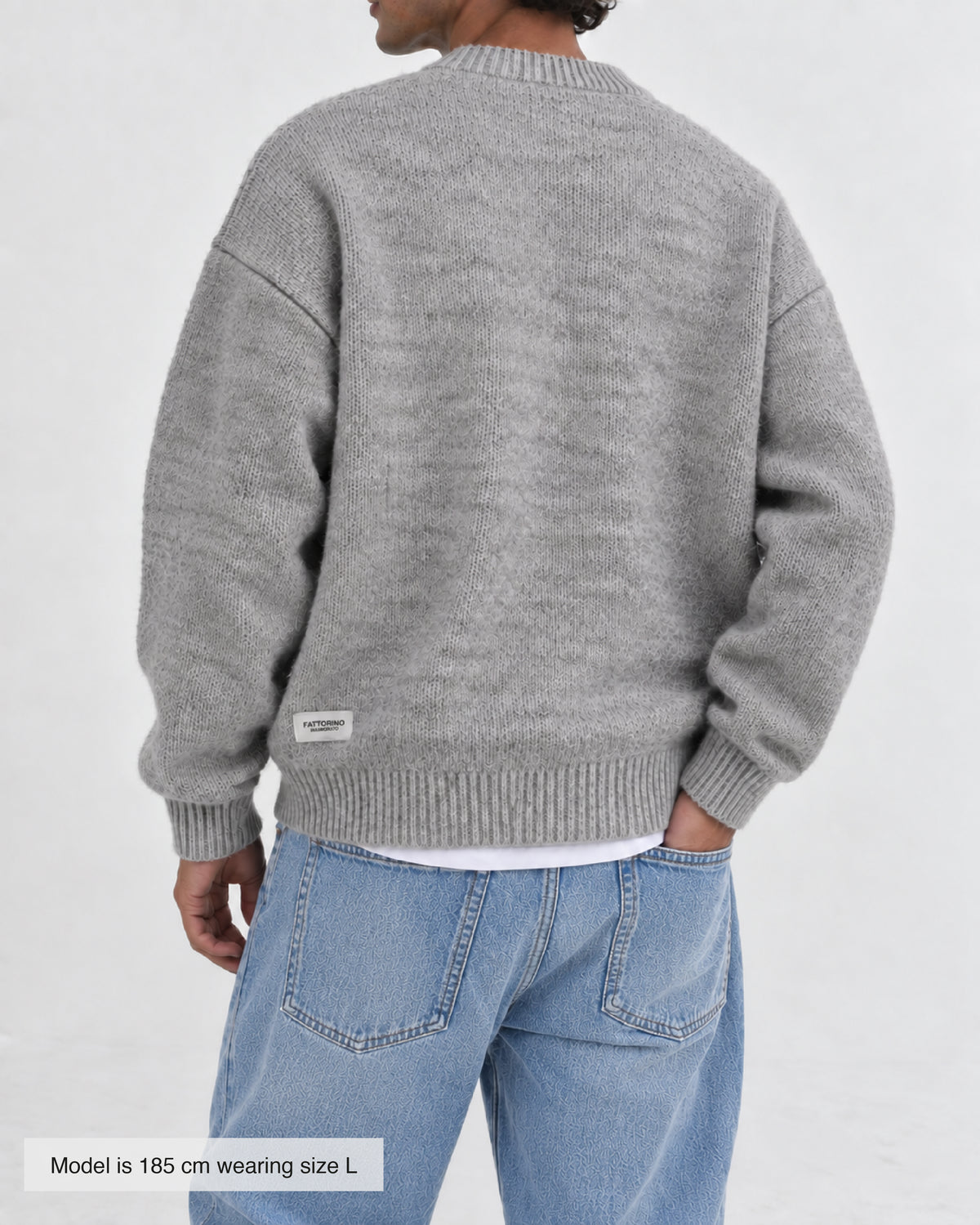 A light grey heathered knit crewneck sweater with ribbed cuffs and hem, displayed flat against a light gray background. Fattorino Innamorato grey knitwear sweaeter 