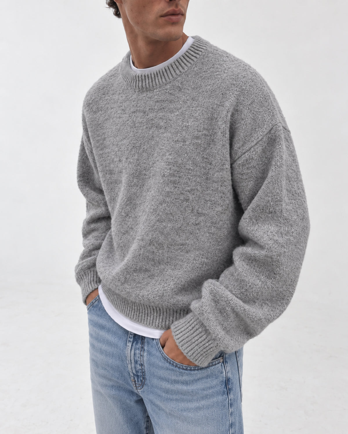 A light grey heathered knit crewneck sweater with ribbed cuffs and hem, displayed flat against a light gray background. Fattorino Innamorato grey knitwear sweaeter 